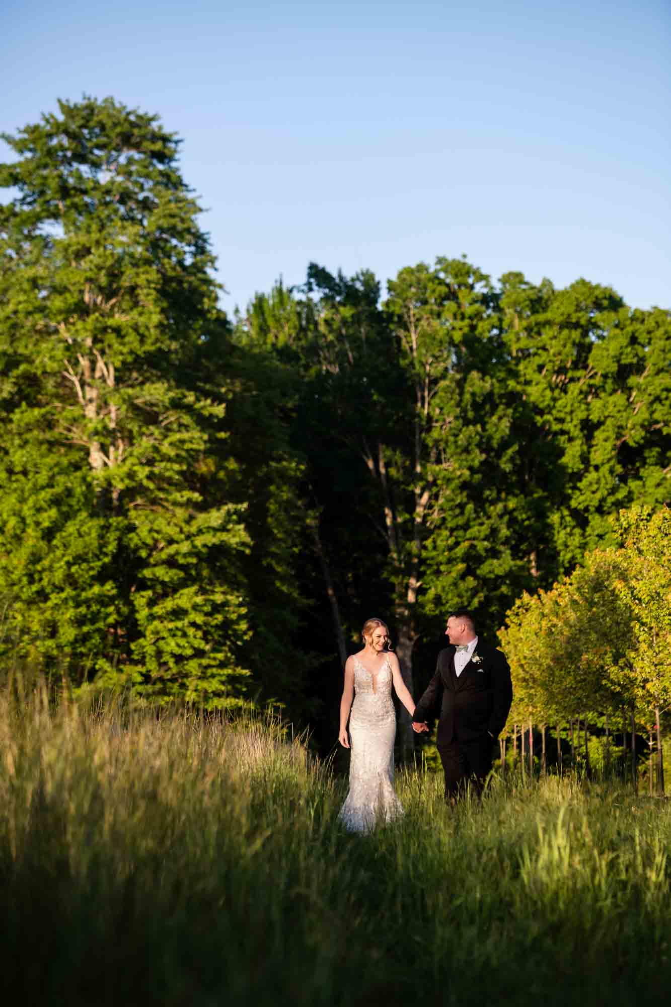 bride and groom walking together in beautiful light at the wedding venue in butler called pinehall at eisler farms